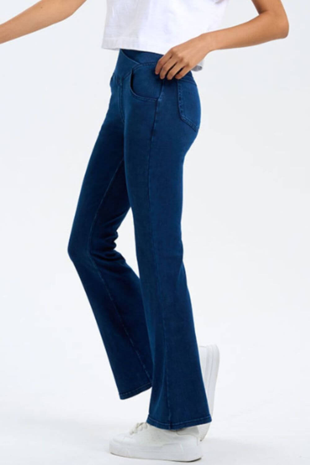 Side view of Basic Bae Pocketed Highly Stretchy Bootcut Jeans in dark blue, showcasing a stylish fit and pockets.