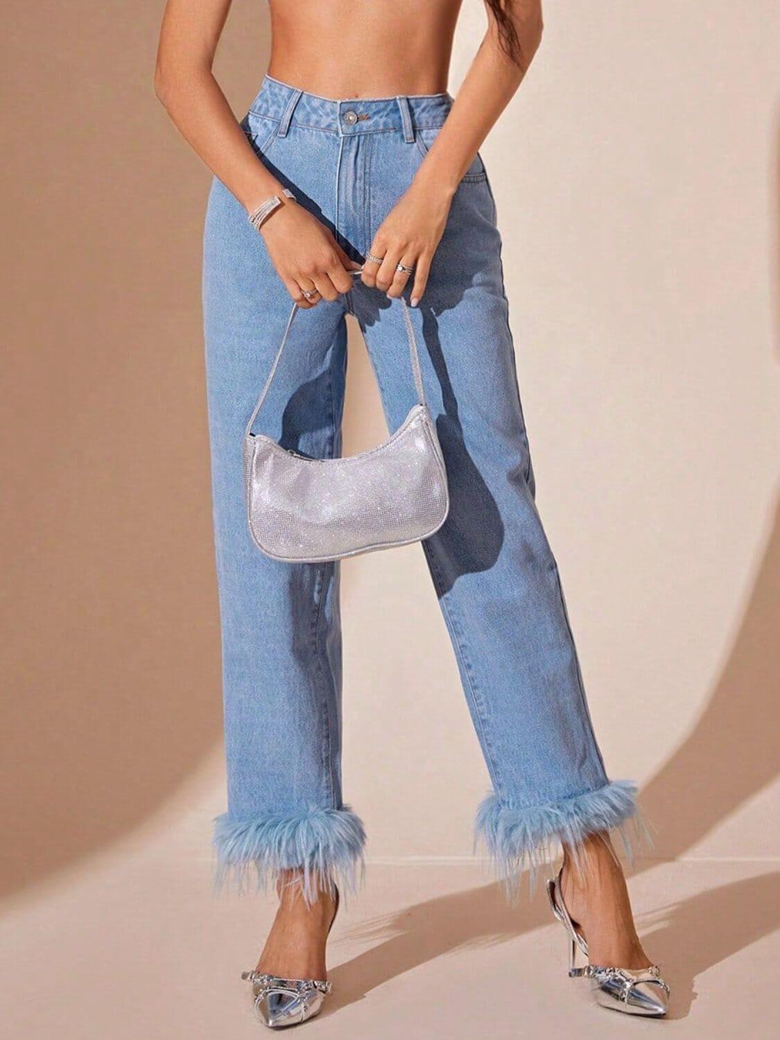 Stylish model wearing Bella Road high rise straight jeans with plush hem, paired with a silver purse and heels.