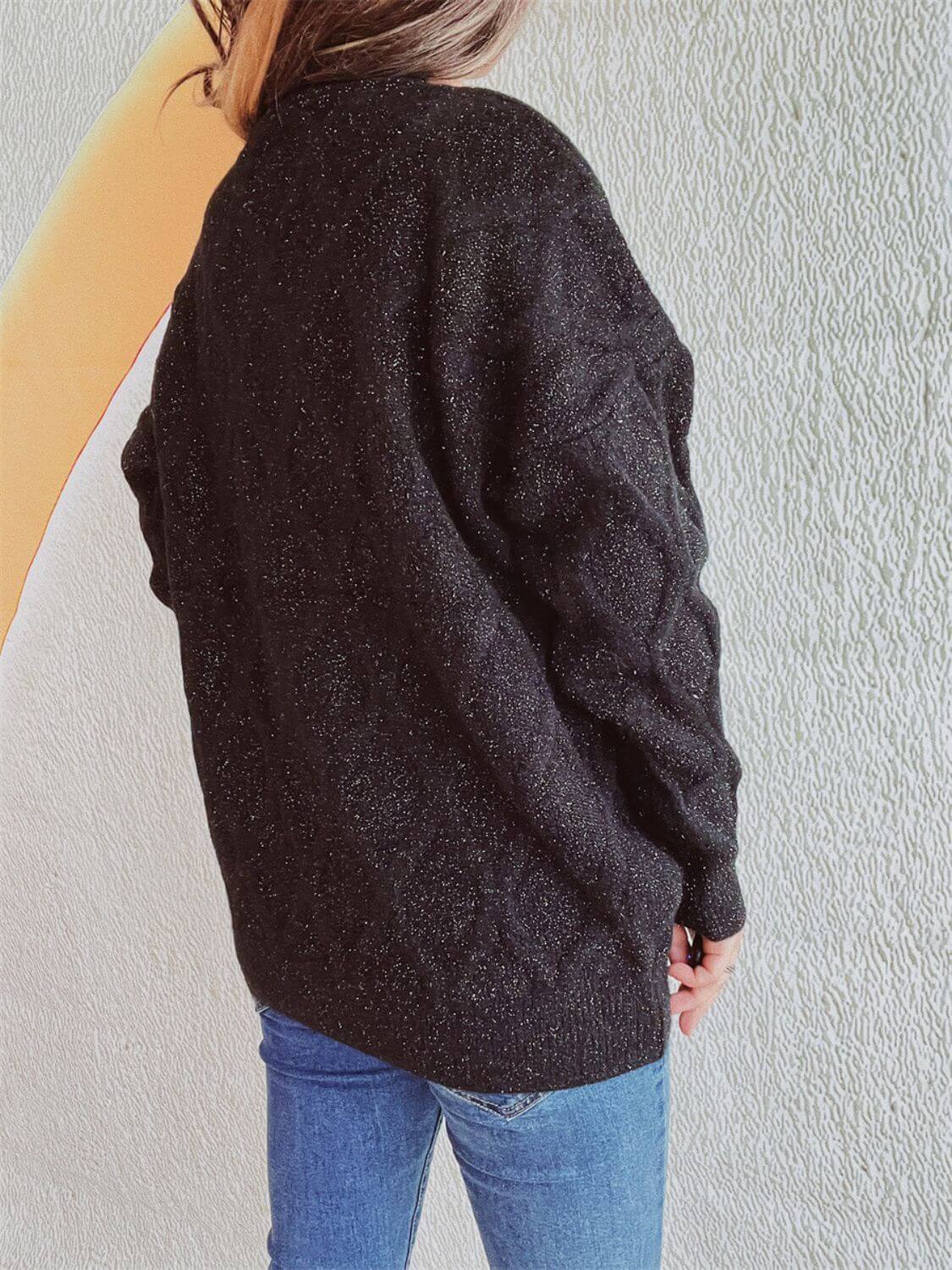 Woman wearing Bella Road Diamond Round Neck Long Sleeve Sweater in black, back view showing diamond pattern and classic design.