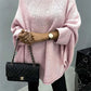 Stylish pink batwing sleeve sweater with round neck paired with black quilted handbag, perfect for a cozy, fashionable look.