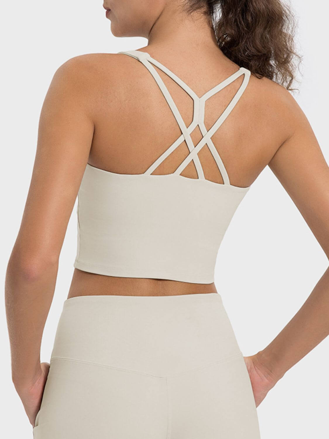 Back view of the Millennia Crisscross Round Neck Active Tank showcasing stylish sheerness and crisscross straps.