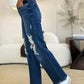 Woman wearing full size mid rise distressed raw hem Judy Blue Jeans with white sneakers.