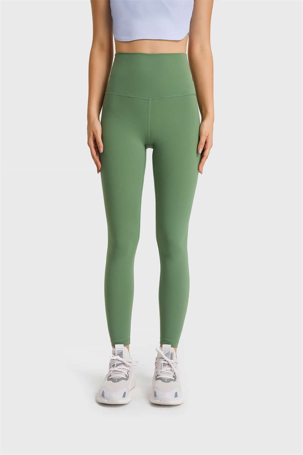 Millennia Ultra Soft High Waist Leggings in green, paired with a light blue top and stylish sneakers for a chic athleisure look.