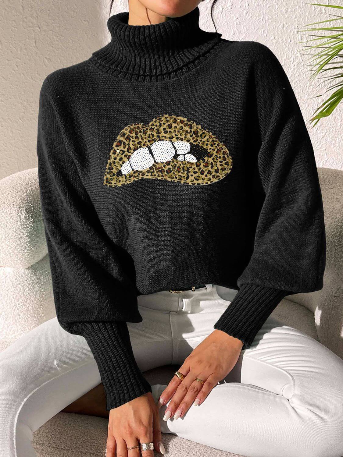 Woman wearing Bella Road Lip Turtleneck Long Sleeve Sweater in black with leopard print lips design.