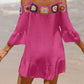 Crochet cold shoulder three-quarter sleeve cover up with ruffled sheer fabric in bright pink, worn at the beach.