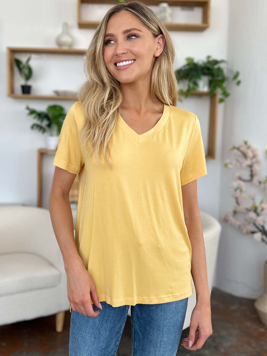 Woman wearing Bamboo V-Neck High-Low T-Shirt in yellow with slightly stretchy fabric made of 95% bamboo and 5% spandex.