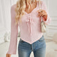 Woman wearing Bella Road Ribbed Drawstring Long Sleeve T-Shirt in pink paired with blue jeans in stylish indoor setting.