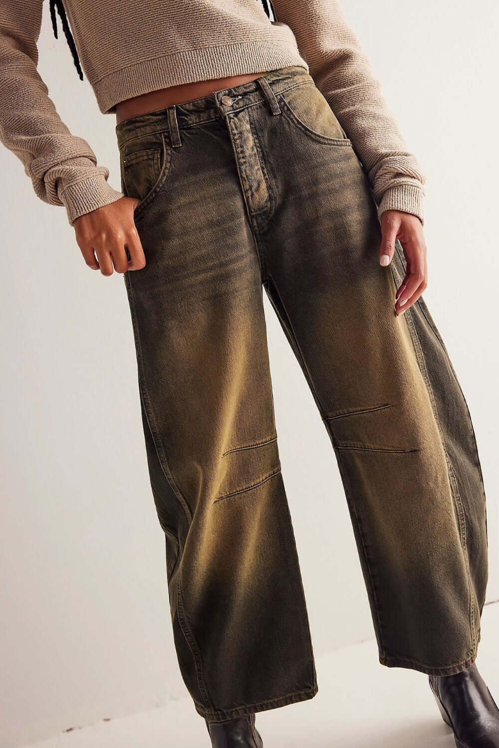 Wide leg buttoned jeans with pockets in denim, featuring a relaxed fit and stylish fade, worn with a beige sweater.