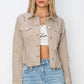 Trendy RISEN cropped denim jacket with raw hem and button-up design, styled for a modern look with distressed details.