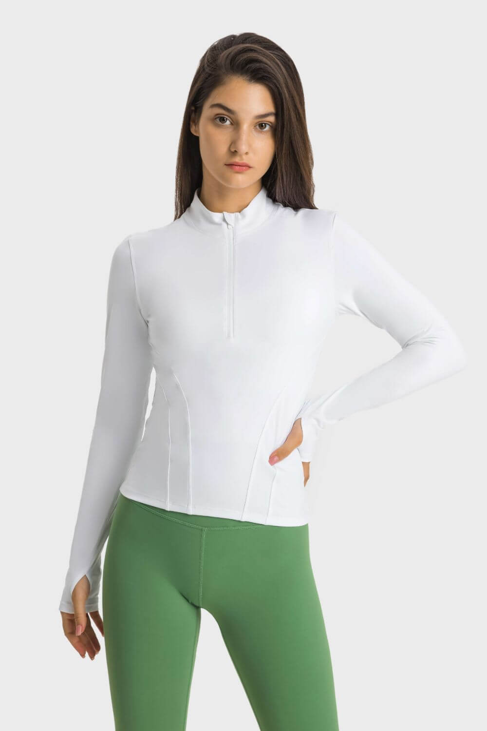 Model wearing the Millennia Half Zip Thumbhole Sleeve Sports Top with green leggings, showcasing a stylish and functional design.