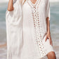 White cutout V-neck three-quarter sleeve cover up with openwork design, sheer material, worn by the beach.