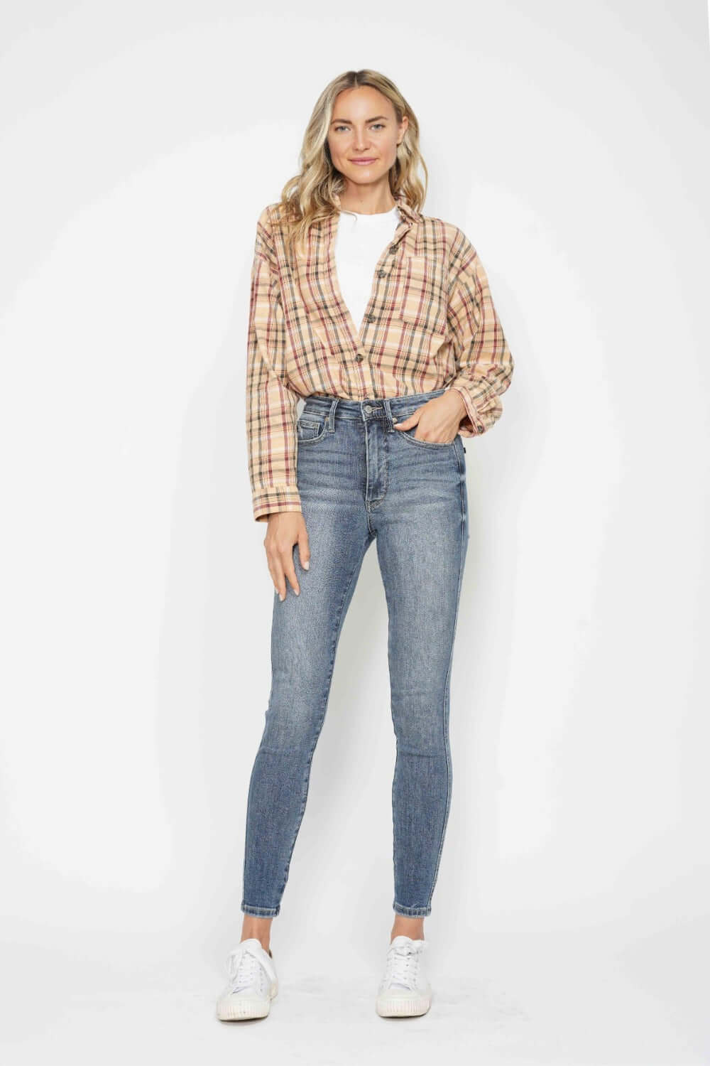 Woman wearing Judy Blue full size tummy control contrast wash skinny jeans and a plaid shirt, showcasing a sleek and stylish look.