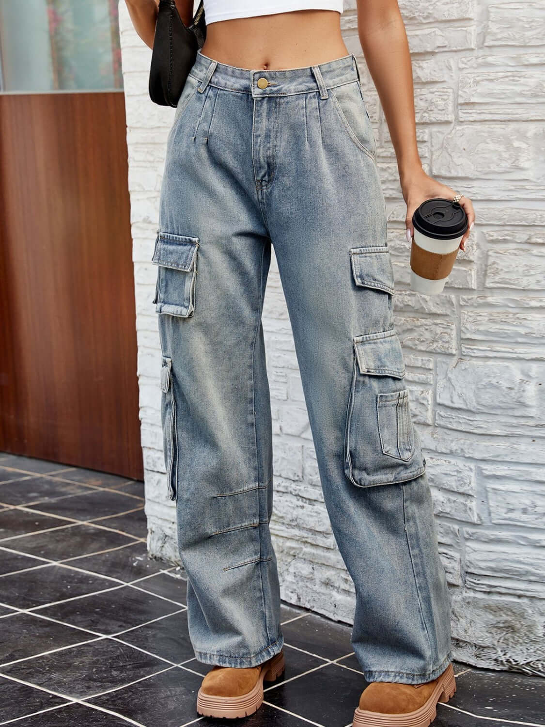 Woman wearing Bella Road Washed Jeans with multiple pockets, front button fastening, and no stretch, holding a coffee cup.