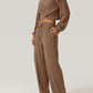 Woman wearing Bella Road Crisscross Round Neck Top and Drawstring Pants Set in brown, showcasing crisscross design and comfortable fit.