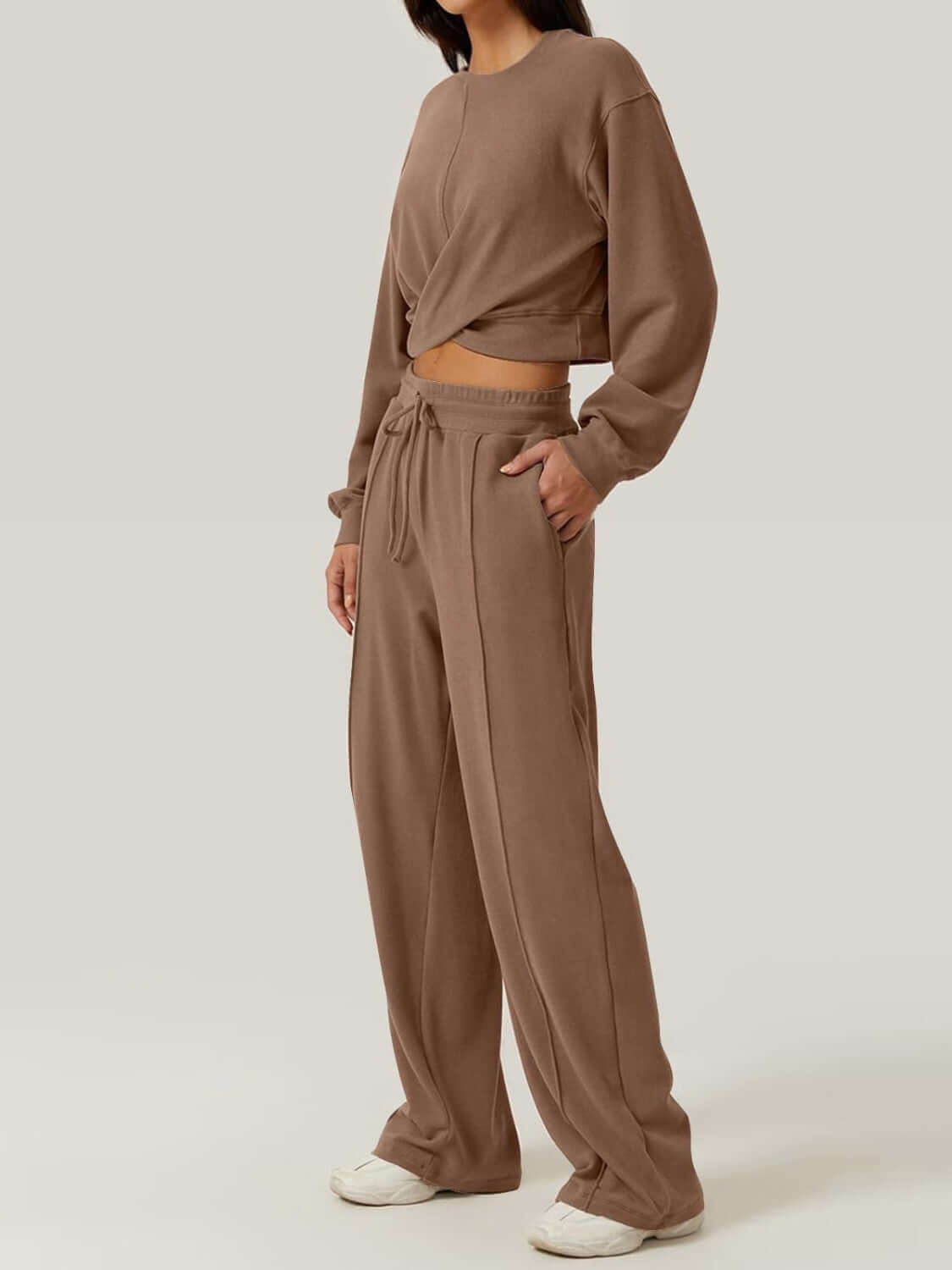 Woman wearing Bella Road Crisscross Round Neck Top and Drawstring Pants Set in brown, showcasing crisscross design and comfortable fit.