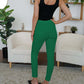 Woman wearing green FAM-FAM High Waist Skinny Pants, standing in a modern living room setting.