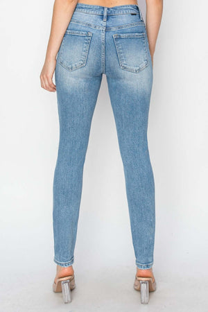 Back view of High Rise Knee Distressed Skinny Jeans in light wash, showcasing their flattering fit and trendy, distressed knee details. Risen Jeans.