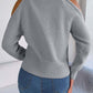 Woman wearing Bella Road Cable-Knit Turtleneck Cold Shoulder Sweater in gray, paired with jeans, showing back view. Cozy and stylish.