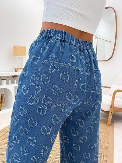 Model showcases Bella Road Denim Heart Washed Straight Leg Jeans with playful heart pattern and elastic waistband.