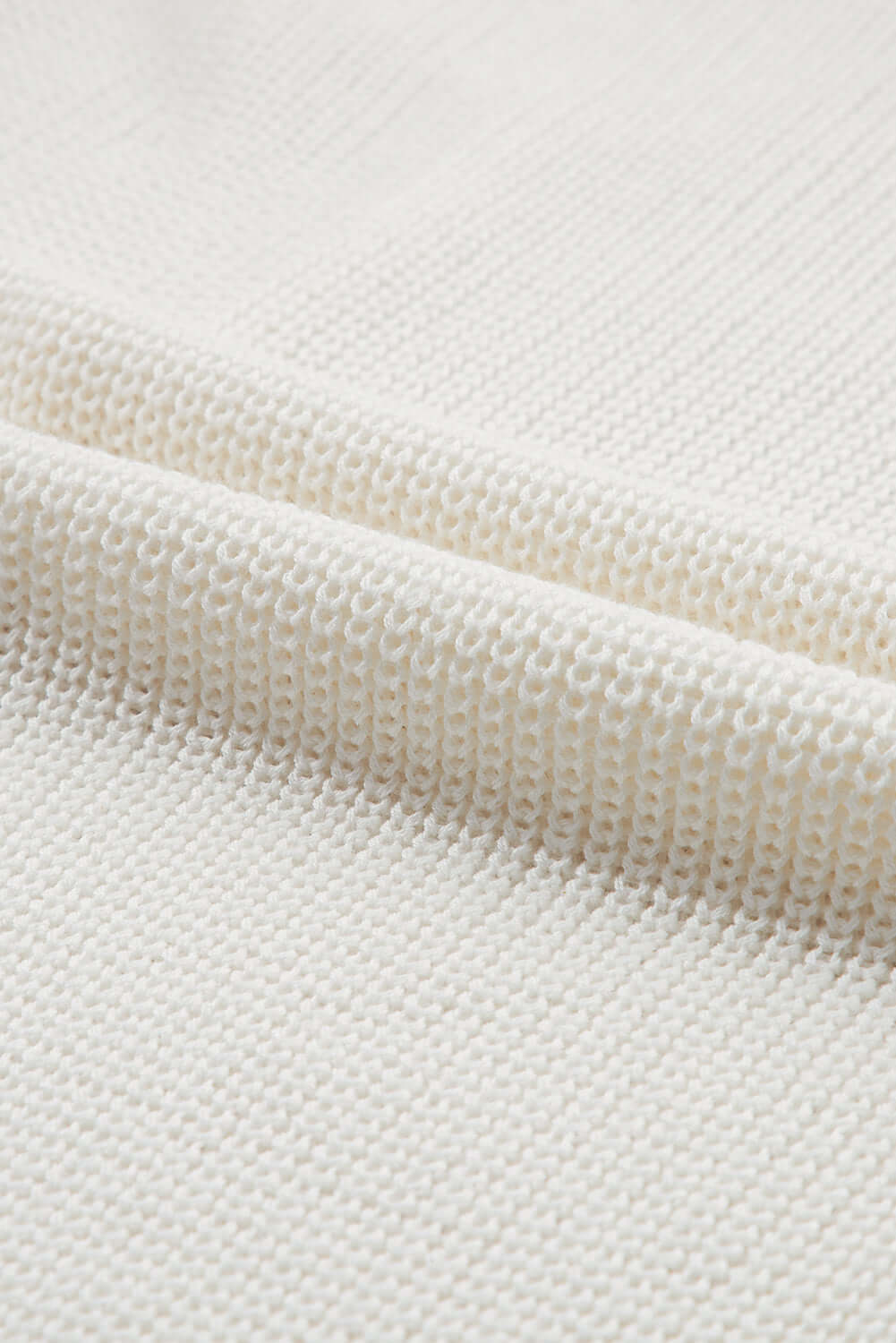 Close-up of soft white fabric showcasing the texture of the Bella Road Central Seam Sleeveless Sweater Vest.