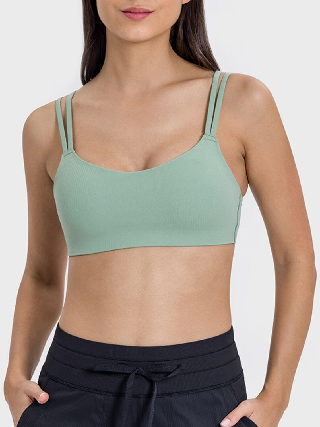 Stylish woman in a mint green double strap active cami, perfect for workouts and casual outings.