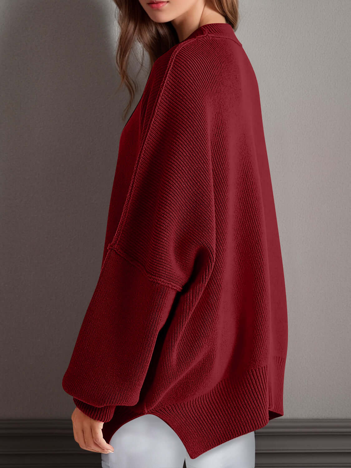 Woman wearing a cozy side slit round neck long sleeve sweater in red, made from 95% cotton and 5% polyester, perfect for a fun and quirky look.