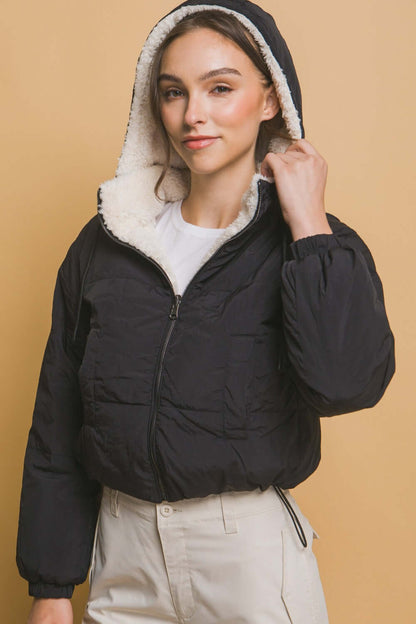 Woman wearing black Love Tree zip-up cropped hooded Sherpa reversible jacket, showcasing cozy and stylish winter outerwear.