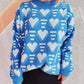 Woman wearing Bella Road Heart Contrast Long Sleeve Dropped Shoulder Sweater in blue with white heart patterns