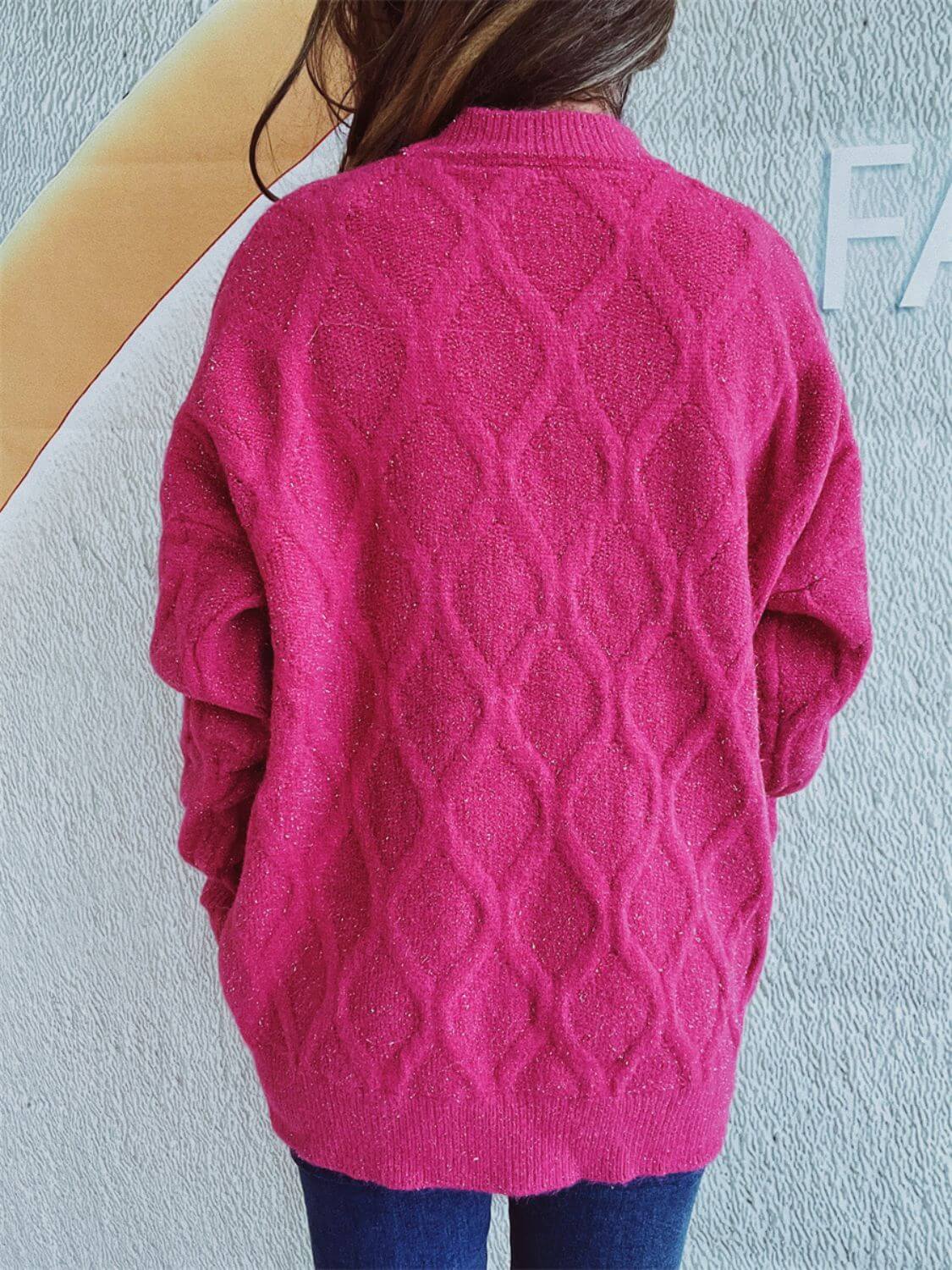 Woman wearing Bella Road Diamond Round Neck Long Sleeve Sweater in pink, showcasing the unique diamond pattern on the back.