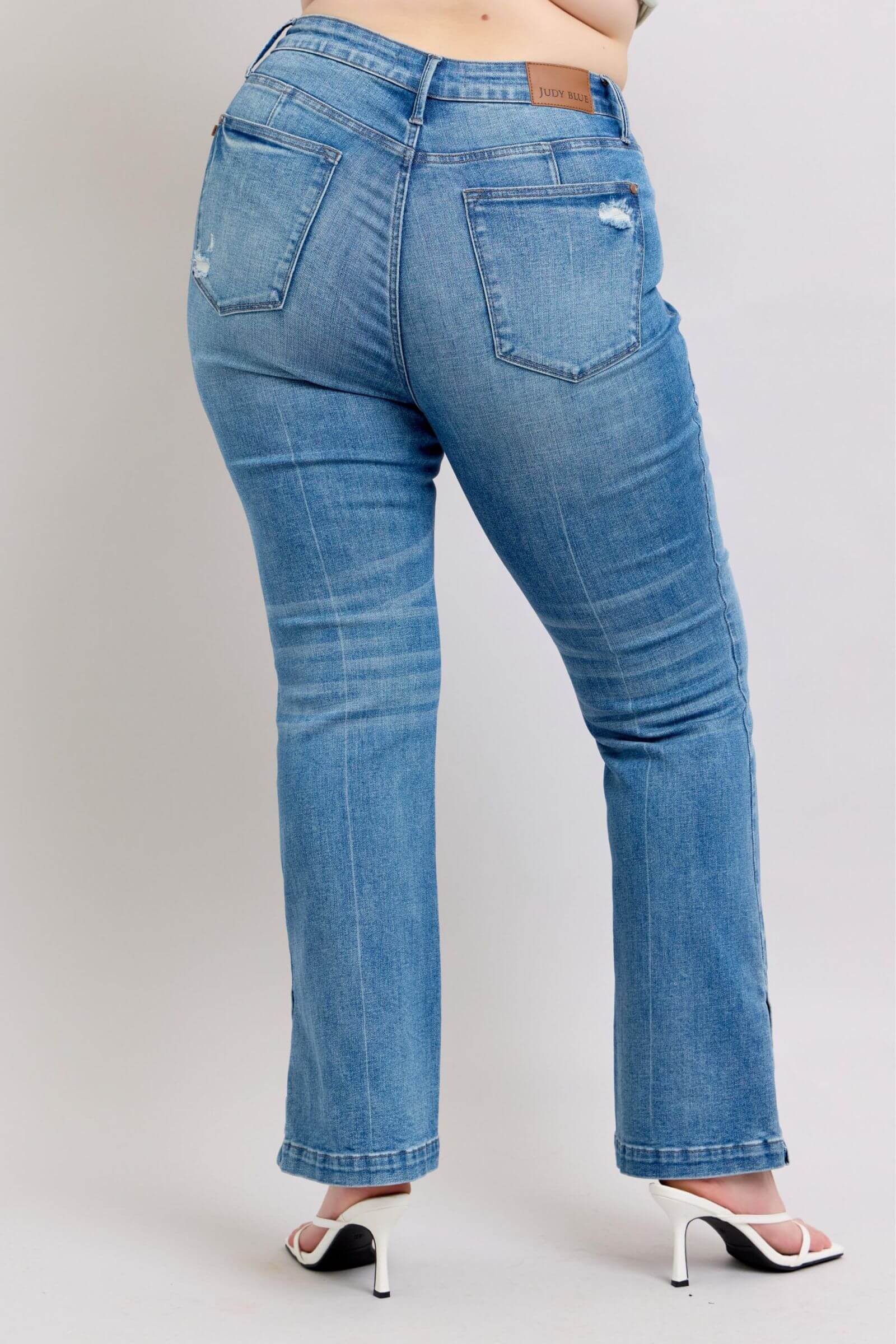 Back view of Judy Blue high waist tummy control vintage wash slim bootcut jeans with side slit detail.