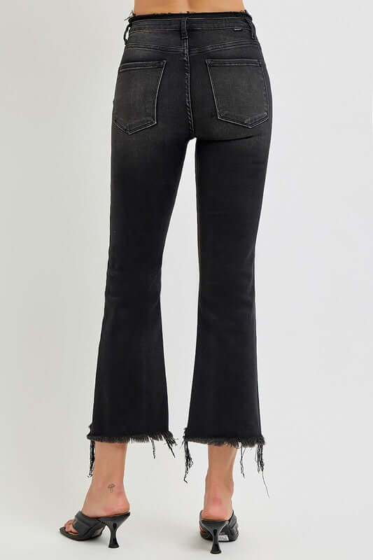 Back view of RISEN full size raw hem cropped flare jeans, featuring a trendy edgy look.