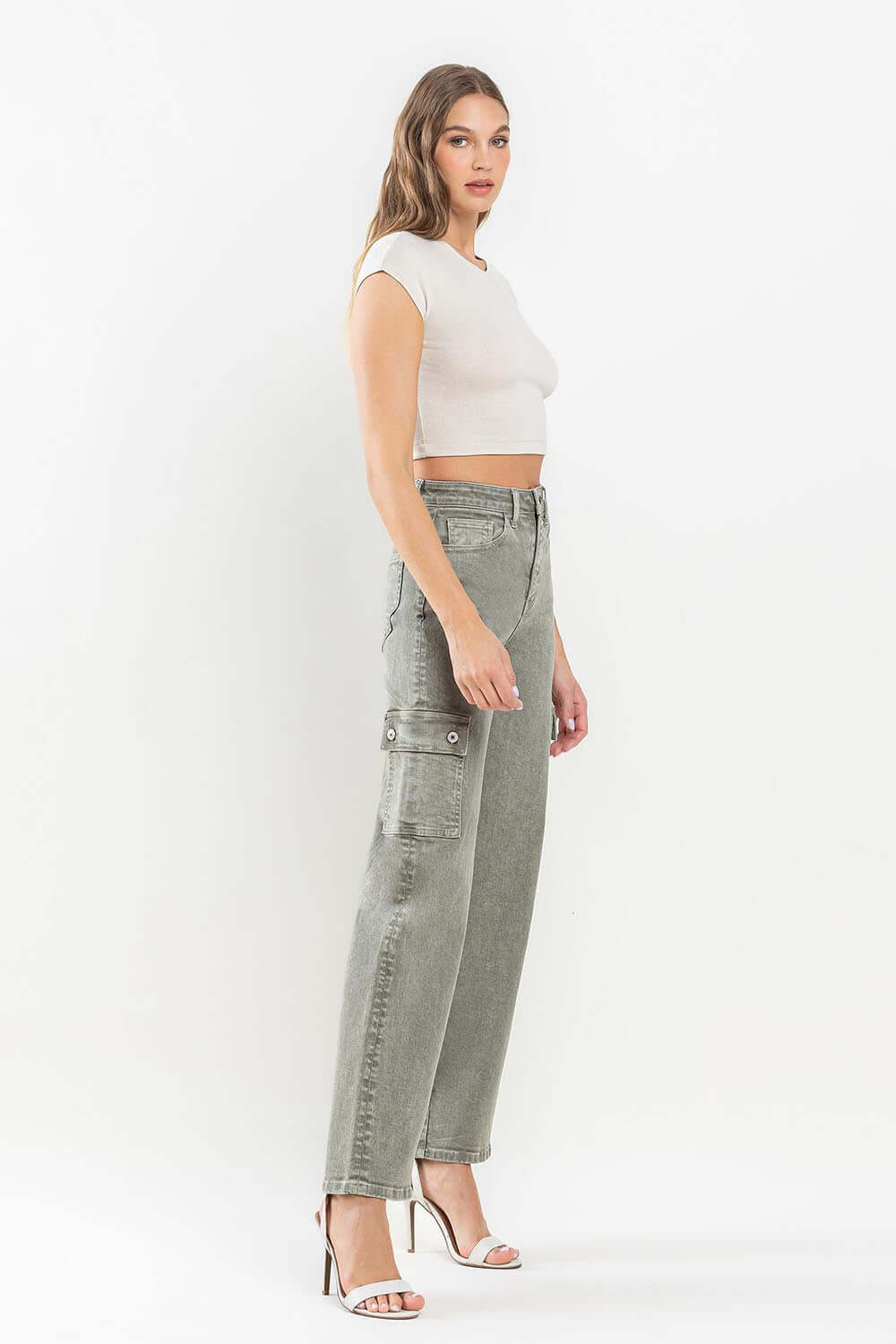 Woman wearing 90's Super High Rise Loose Cargo Jeans with ultra-high waist, loose fit, and cargo pockets, styled with a crop top and heels.