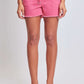 Woman wearing pink YMI Jeans drawstring raw hem shorts for a relaxed and edgy casual look.