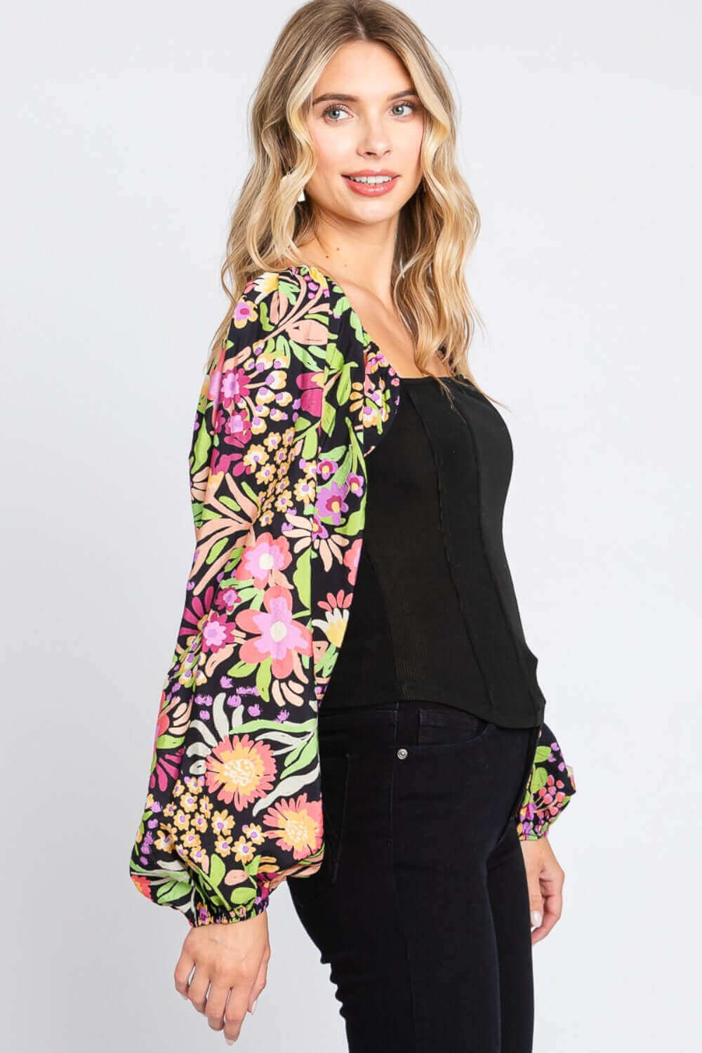 Woman wearing Floral Balloon Sleeve Blouse with elegant floral print and dramatic balloon sleeves, showcasing a chic and feminine fashion-forward look.