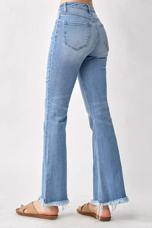 Back view of high rise frayed hem bootcut Risen Jeans, showcasing the timeless and flattering silhouette with edgy frayed hem detail