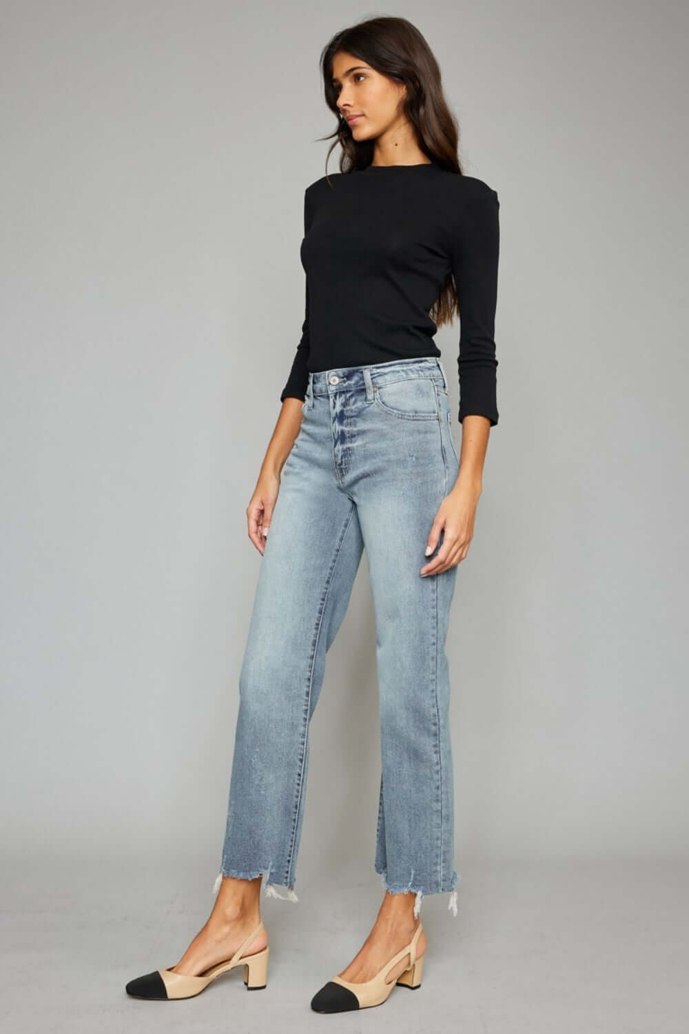 Woman wearing trendy High Waist Raw Hem Cropped Wide Leg Jeans paired with a black top, showcasing a chic and modern look.