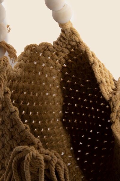 Close-up of the wooden beaded handle braided tote bag showcasing its bohemian woven texture and natural elegance.