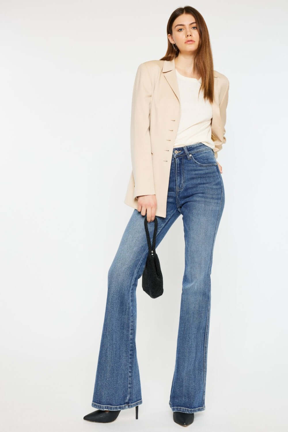 Woman wearing Cat's Whiskers High Waist Flare Jeans with beige blazer, holding black handbag, stylish and fashion-forward look.