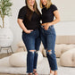 Women wearing RFM Jeans Crop Dylan Full Size Tummy Control Distressed High Waist Raw Hem Jeans, standing in a stylish room.