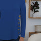 Woman wearing a blue FAM-FAM round neck long sleeve t-shirt with decorative buttons, perfect for casual style and comfort.