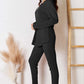 Woman wearing notched long sleeve top and pants set in black, ribbed texture, slightly stretchy, two-piece outfit, standing near a ladder.