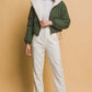 Stylish woman wearing Love Tree cropped hooded Sherpa reversible jacket in green, paired with white pants for a chic casual look.