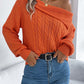 Woman wearing Bella Road Cable-Knit One Shoulder Long Sleeve Sweater in orange, paired with blue jeans.