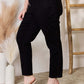 High-waist rhinestone embellished slim black jeans by Judy Blue, shown from the side with hand in pocket