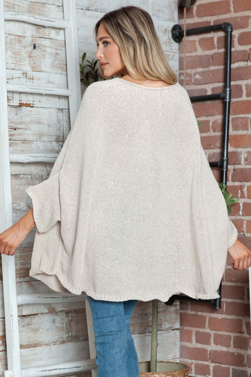 Woman wearing Bella Road Round Neck Batwing Sleeve Sweater with jeans, showcasing its cozy and stylish design.