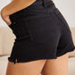 Woman wearing RFM Jeans tummy control high waist denim shorts showcasing slimming fit and frayed hem.