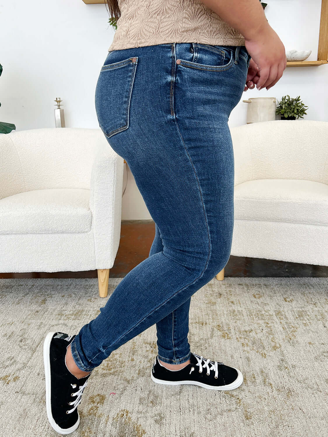 Woman wearing Classic Handsand Skinny Jeans with a hand-sanded finish and black sneakers, showcasing a flattering fit and vintage vibe.