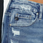 Close-up of Kancan high-rise slim straight jeans with distressed details and wide waistband, showcasing trendy medium stone wash denim.