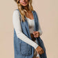 Stylish woman in a BiBi braided trim open front denim vest with pockets, paired with a hat and top, showcasing chic fashion.