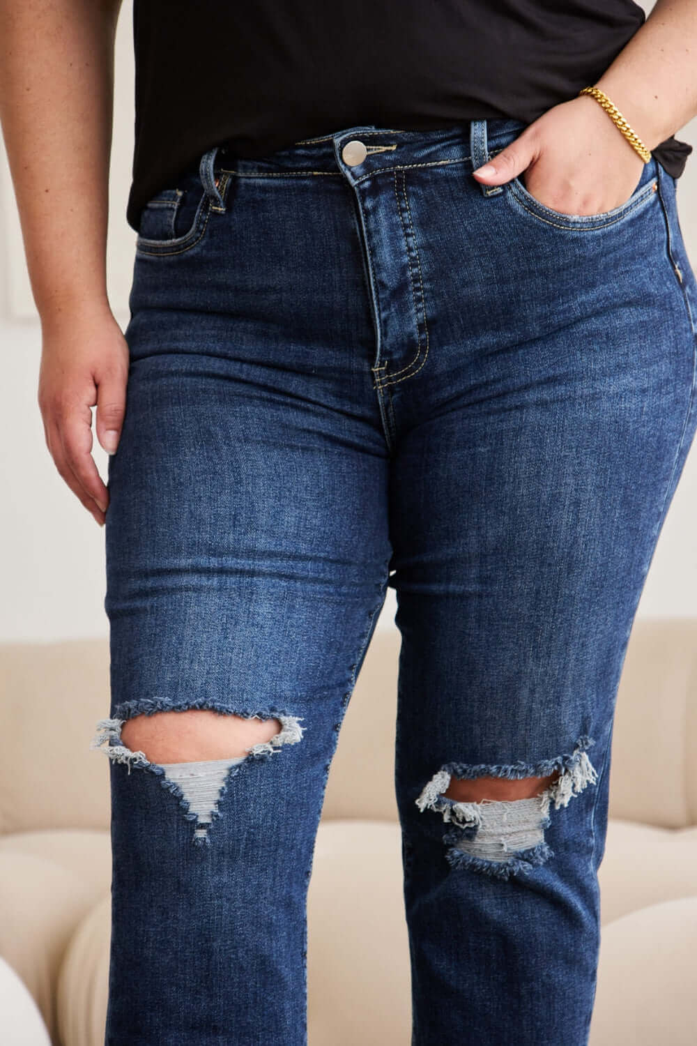 Woman wearing high waist distressed jeans with tummy control and raw hem by RFM Jeans.